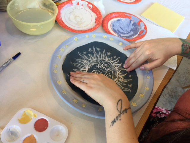 Placing a custom stencil on a ceramic dish for screen printing